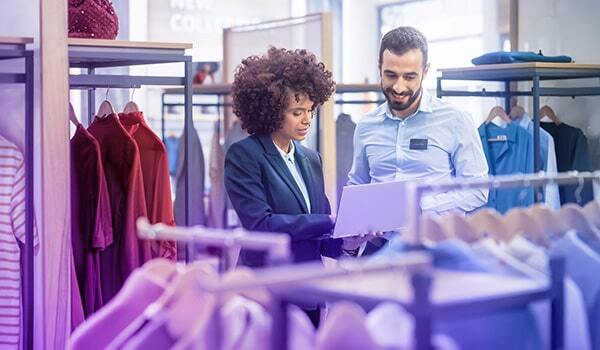 Sales associates looking at a laptop in store